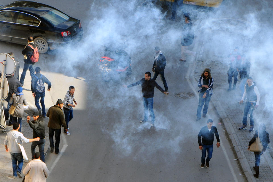 Protestors are seen in a smoke of gas during a demonstration to denounce the Islamist-led government, in Tunis, Saturday, Feb 25, 2012. More than 4,000 members of Tunisia's main trade union marched through the center of the capital, prompted by attacks on the union's offices around the country, which it blamed on members of Ennahda, the moderate Islamist party that won elections in October(AP Photo/Hassene Dridi)