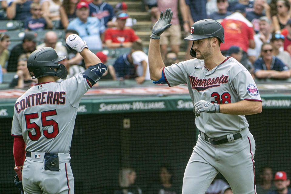 Minnesota Twins' Matt Wallner, right is congratulated by Mark Contreras after hitting a solo home run off Cleveland Guardians starting pitcher Shane Bieber during the eighth inning in the first game of a baseball doubleheader in Cleveland, Saturday, Sept. 17, 2022. Wallner made his Major League debut in the game. (AP Photo/Phil Long)