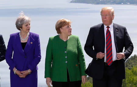 Britain's Prime Minister Theresa May, Germany's Chancellor Angela Merkel and U.S. President Donald Trump pose during a family photo at the G7 Summit in the Charlevoix city of La Malbaie, Quebec, Canada, June 8, 2018. REUTERS/Yves Herman