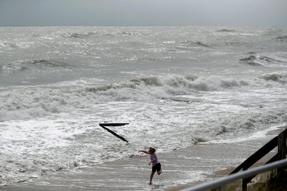 Weston Lee, of Vero Beach, throws a piece of wood into the high surf from the Atlantic Ocean, in advance of the potential arrival of Hurricane Dorian, in Vero Beach, Fla., Monday, Sept. 2, 2019. (AP Photo/Gerald Herbert)