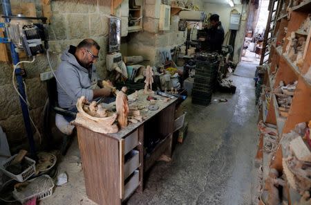 Palestinian workers carve figurines for sale during Christmas season, at a workshop in Bethlehem in the occupied West Bank, December 10, 2018. REUTERS/Raneen Sawafta
