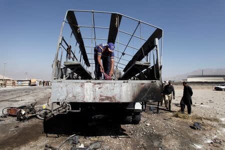 ATTENTION EDITORS - VISUAL COVERAGE OF SCENES OF INJURY OR DEATH A rescue worker inspects as policemen gather near a truck after a blast in Quetta, Pakistan October 18, 2017. REUTERS/Naseer Ahmed