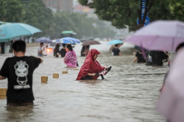 As heavy rain pounded central China, floodwaters trapped people in a subway