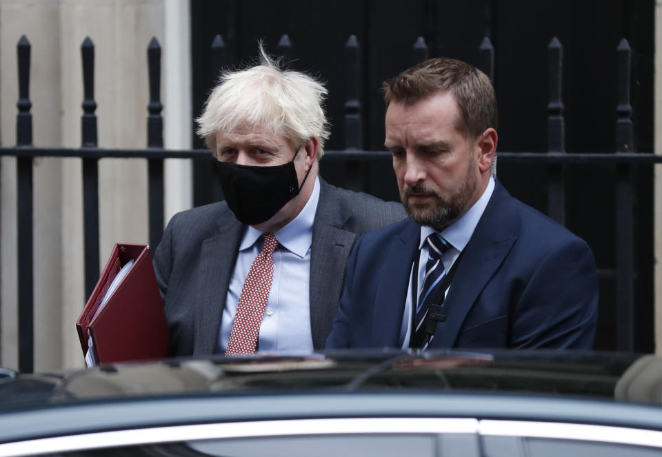 Britain's Prime Minister Boris Johnson flanked by his bodyguard leaves 10 Downing Street for the House of Commons to attend his weekly Prime Minister's Questions in London, Wednesday, Sept. 30, 2020. (AP Photo/Alastair Grant)