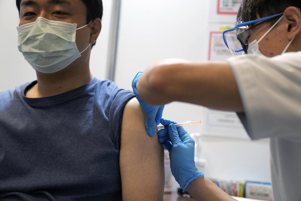 A local resident receives the booster shot of the Moderna coronavirus vaccine at a mass vaccination center operated by Japanese Self-Defense Force Monday, Jan. 31, 2022, in Tokyo. (AP Photo/Eugene Hoshiko, Pool)