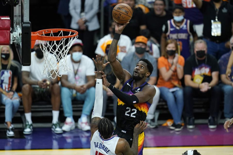 Phoenix Suns center Deandre Ayton, right, shoot over Los Angeles Clippers guard Paul George, left, during the first half of Game 1 of the NBA basketball Western Conference finals Sunday, June 20, 2021, in Phoenix. (AP Photo/Ross D. Franklin)