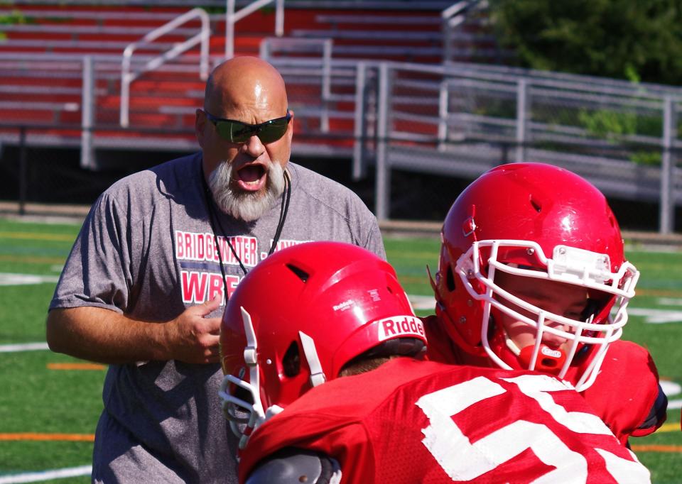 Bridgewater-Raynham football head coach Lou Pacheco barks instructions to his players during Trojan practice on Tuesday, Aug. 22, 2023.