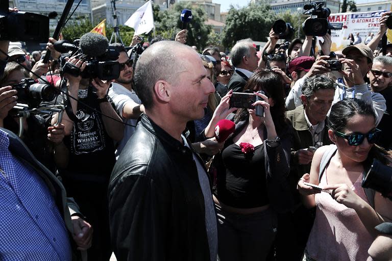 People film Greek Finance Minister Yanis Varoufakis as he attends a demonstration organised by unions of the public and private sector to mark May Day, in central Athens on May 1, 2015