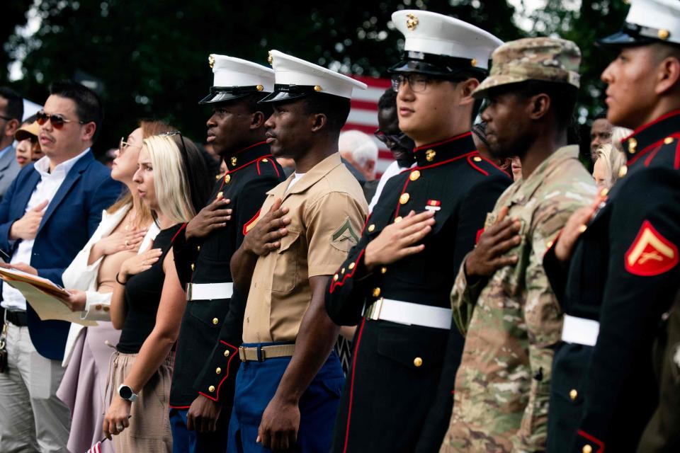 New U.S. citizens recite the Pledge of Allegiance at a naturalization ceremony on July 4, 2023, at George Washington's Mount Vernon in Northern Virginia.