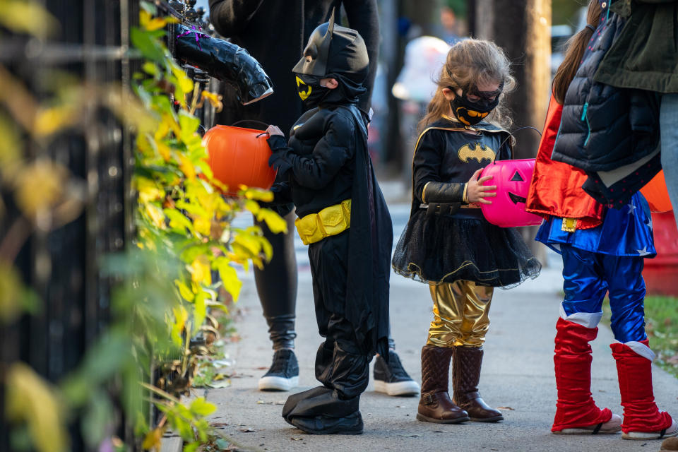 Children receive treats by candy chutes while trick-or-treating for Halloween in the Bronx, N.Y., on Oct. 31, 2020. (David Dee Delgado / Getty Images file)