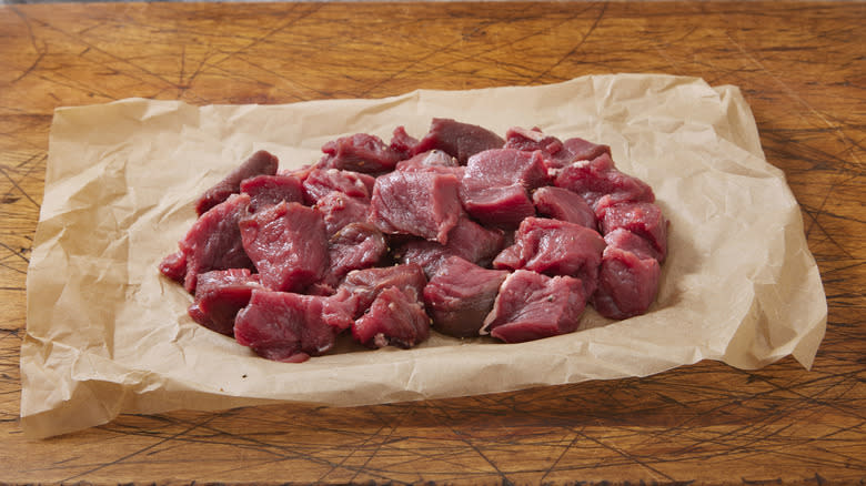 raw chunks of moose meat on parchment
