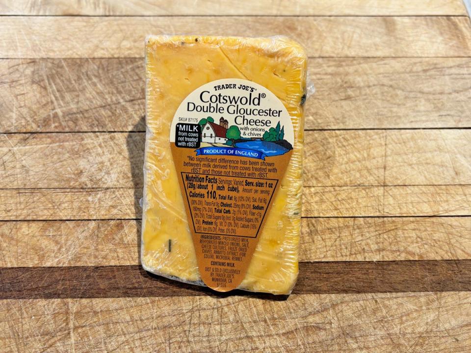 An orange wedge of cheddar with orange label reading "Cotswold double Gloucester cheese"