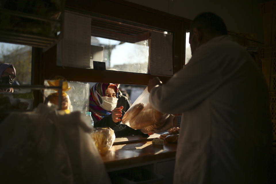 People buy bread in the Istanbul Municipality's bread kiosk in Istanbul, Thursday, Dec. 2, 2021. Turkey's government and central bank have taken a series of complex steps in recent weeks to prop up a beleaguered economy crippled by skyrocketing consumer prices, instead of ending a much-criticized plan to cut interest rates. (AP Photo/Emrah Gurel)