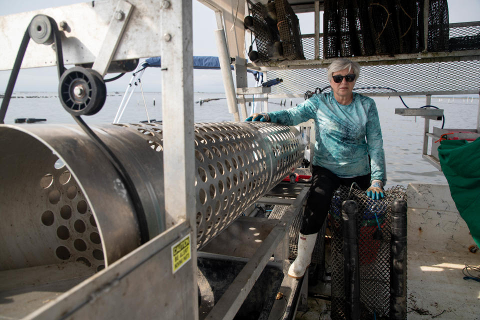 OysterMom Deborah Keller stands next to her tumbler machine on her boat in her Oyster Bay lease in Crawfordville Wednesday, June 16, 2021.