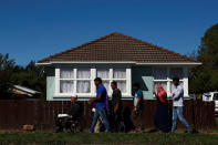 Farid Ahmed (in the wheelchair), survivor of the Christchurch shootings where her wife Husna was killed, is joined by his relatives as he visits his neighbors to offer thanks for their support, in Christchurch, New Zealand March 24, 2019. When his neighbours heard of his wife's death, "they came running... they were in tears," Ahmed said. "That was wonderful support and expression of love." He is on a mission to bring together his community and spread forgiveness in the wake of the mass shooting that stole his wife's life. REUTERS/Edgar Su