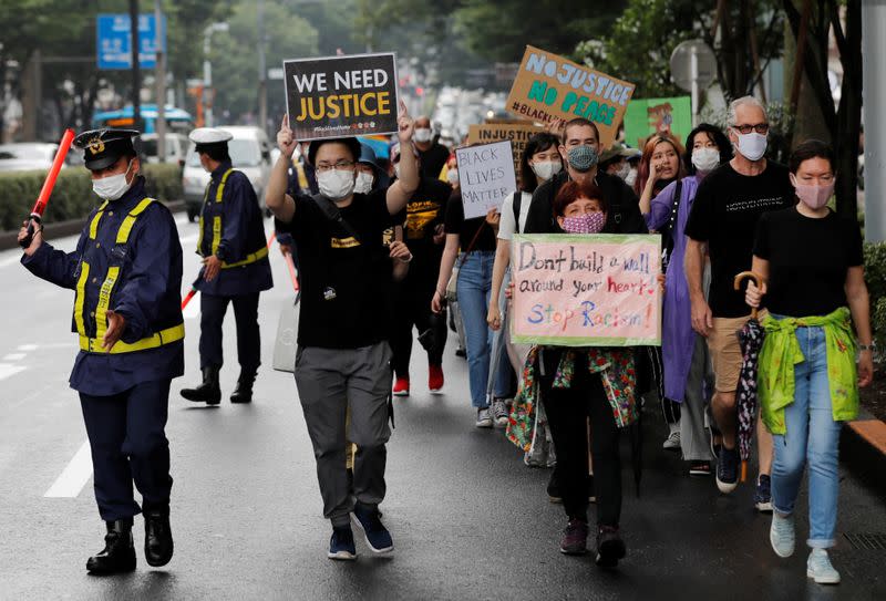 People wearing face masks march during a Black Lives Matter protest following the death in Minneapolis police custody of George Floyd, in Tokyo