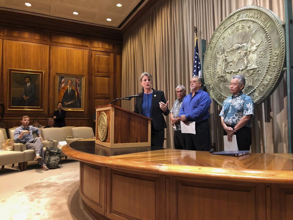 Hawaii Attorney General Clare Connors talks to reporters in Honolulu on Friday, Sept. 13, 2019 about threats state employees have received amid the heated debate over building a giant telescope on the state's highest peak. Behind her are Department of Hawaiian Homelands Director William Aila Jr., left, Department of Public Safety Director Nola Espinda, middle, and Gov. David Ige. (AP Photo/Jennifer Sinco Kelleher)