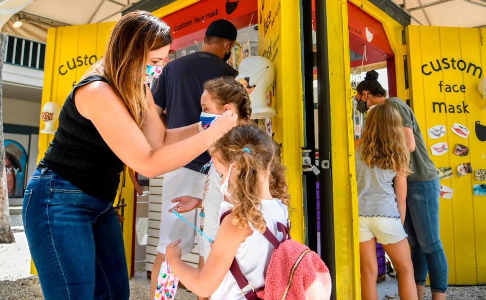 Venessa Abaugh, left, helps her daughter Aubrey, 6.5-years old, center, with her face covering as her youngest daughter, Avery, 4.5-years old, front, waits to be fitted with her new mask on Thursday, July 2, 2020, at Custom Face Mask in Coligny Plaza Shopping Center on Hilton Head Island. “I never thought we’d be shopping for face masks while on vacation,” the Columbus, Ohio resident said as they looked at design variations at the shopping kiosk. Wearing face masks is nothing new to the visiting Ohioans, if you don’t wear them, Abaugh said “people look at you like you have the plague.”