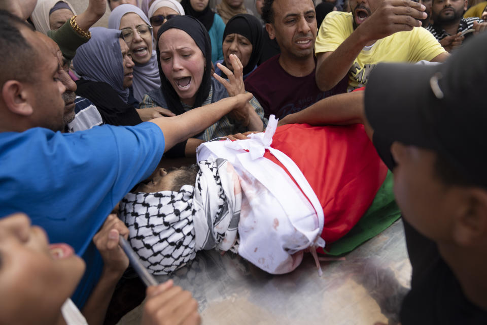 Mourners react while they take the last look at the body of Palestinian Shadi Jalaita, 44 during his funeral in the West Bank city of Jericho Tuesday, April 23, 2024. Israeli forces shot dead a Palestinian man early Tuesday in the West Bank city of Jericho, an eyewitness and Palestinian officials said. The Palestinian Health Ministry said he suffered a fatal gunshot wound to the chest. (AP Photo/Nasser Nasser)