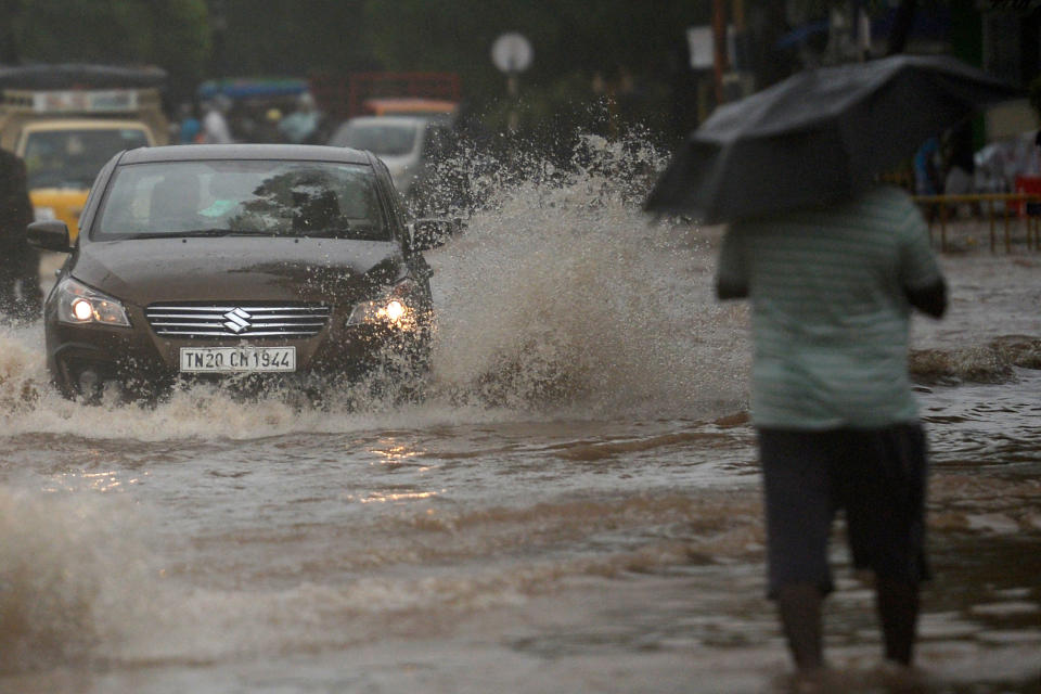 Motorists make their way along a waterlogged road after heavy rains following Cyclone Nivar landfall, in Puducherry on November 26, 2020. (Photo by ARUN SANKAR/AFP via Getty Images)
