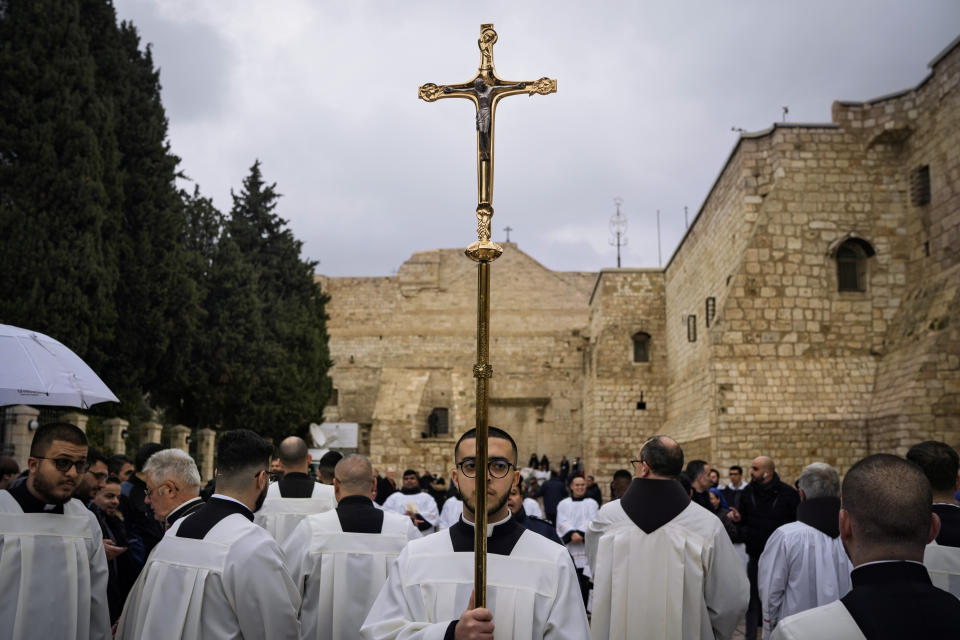 Catholic clergy walk in procession next to the Church of the Nativity, traditionally believed to be the birthplace of Jesus, on Christmas Eve, in the West Bank city of Bethlehem, Sunday, Dec. 24, 2023. Bethlehem is having a subdued Christmas after officials in Jesus' traditional birthplace decided to forgo celebrations due to the Israel-Hamas war. (AP Photo/Leo Correa)