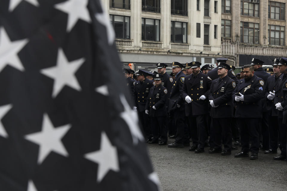 New York Police officers line up along Fifth Avenue outside St. Patrick's Cathedral for Officer Wilbert Mora's funeral, Wednesday, Feb. 2, 2022, in New York. For the second time in under a week, police converged on New York City's St. Patrick's Cathedral to pay tribute to a young officer gunned down while answering a call for help in Harlem. Mora was shot along with Officer Jason Rivera on Jan. 22 while responding to a call about a domestic argument in an apartment. (AP Photo/Yuki Iwamura)