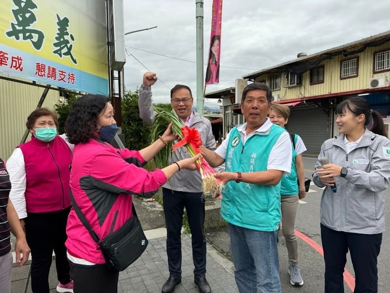 宜蘭縣議員補選  王義川陪藍萬義掃街拜票 宜蘭縣員山鄉縣議員補選將在13日投票，民進黨政策 會執行長王義川（中後）9日前往宜蘭輔選，陪同黨 縣議員候選人藍萬義（前右2）徒步掃街拜票，有支 持者送上蒜苗，預祝高票當選。 （藍萬義競選辦公室提供） 中央社記者王朝鈺傳真  113年4月9日 