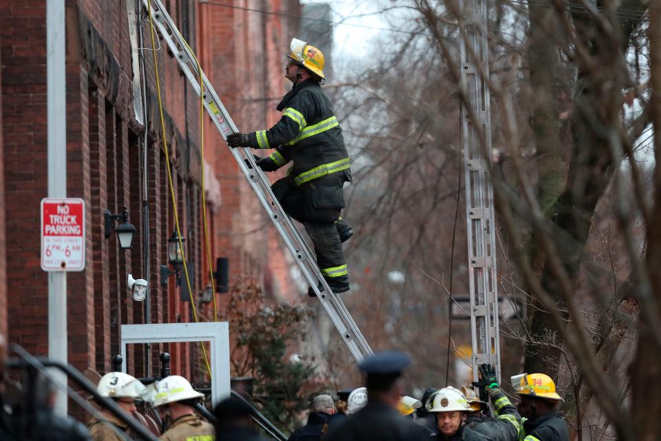 Philadelphia firefighters work at the scene of a deadly row house fire, Wednesday, Jan. 5, 2022, in the Fairmount neighborhood of Philadelphia.