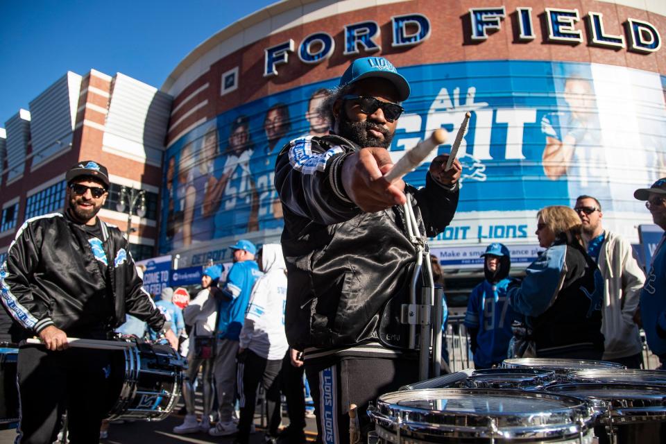 Detroit Lions drumline member DeAndre Hicks performs along the way back to the break room after a performance for fans waiting at Gate A of Ford Field before the game against the Chicago Bears on Sunday.