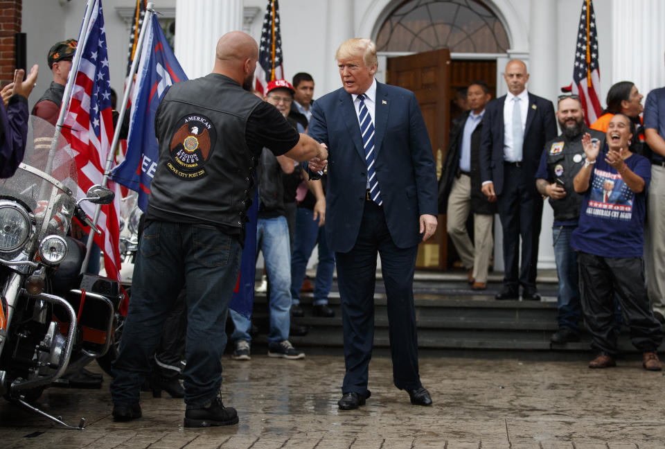 President Donald Trump greets cheering members of Bikers for Trump and supporters, Saturday, Aug. 11, 2018, at the clubhouse of Trump National Golf Club in Bedminster, N.J. (AP Photo/Carolyn Kaster)