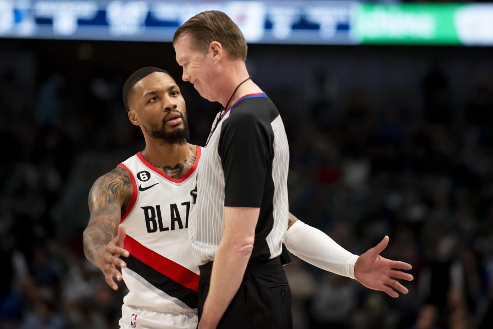 Portland Trail Blazers guard Damian Lillard, left, converses with a referee in the first half of an NBA basketball game against the Dallas Mavericks in Dallas, Friday, Dec. 16, 2022. (AP Photo/Emil Lippe)