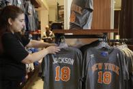 A New York Knicks store employee arranges Phil Jackson t-shirts prior to a news conference where he was introduced as the new president of the New York Knicks, Tuesday, March 18, 2014 in New York. Jackson, who won two NBA titles as a player with the Knicks, also won 11 championships while coaching the Chicago Bulls and the Los Angeles Lakers. (AP Photo/Mark Lennihan)