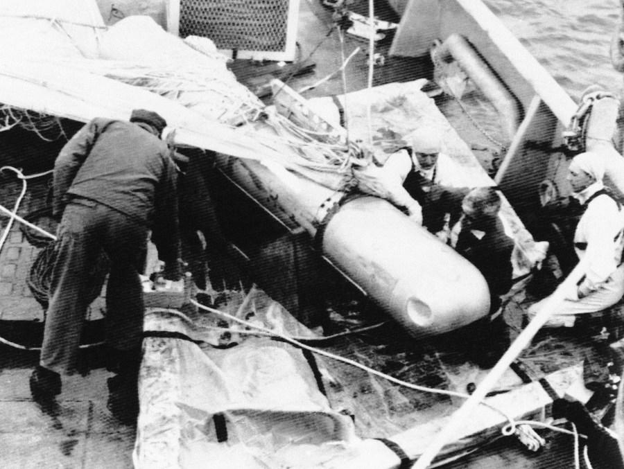 U.S. Navy ordnance men check for contamination on an H-bomb on deck of the USS petrel off Palomares Beach, Spain on April 8, 1966, after the bomb was successfully recovered from the Mediterranean Sea. Bomb had been lost since last January following the crash of two U.S. Air Force planes. (AP Photo)