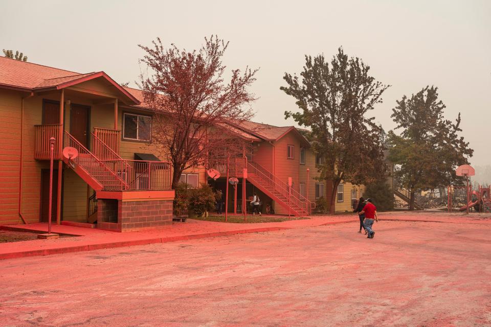 Residents collect belongings from a housing structure saved by fire retardant in a neighborhood largely destroyed by wildfire on September 13, 2020 in Talent, Oregon.