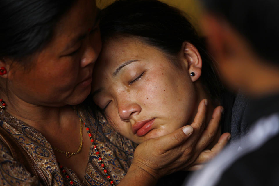 La hija del alpinista nepalí Ang Kaji Sherpa, muerto en una avalancha en el Monte Everest, llora mientras el cadáver de su padre es llevado al Monasterio Sherpa en Katmandú, Nepal, el sábado 19 de abril de 2014. (Foto AP/Niranjan Shrestha)