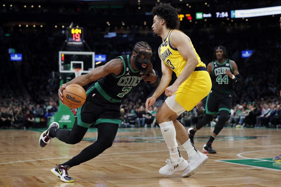 Boston Celtics' Jaylen Brown (7) drives past Indiana Pacers' Jordan Nwora (13) during the first half of an NBA basketball game Friday, March 24, 2023, in Boston. (AP Photo/Michael Dwyer)