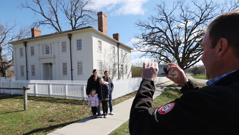 Adam George, of Cody, Wyoming,  takes a photo of his family near the Joseph and Emma Smith Mansion House in Nauvoo on Wednesday, March 27, 2024.