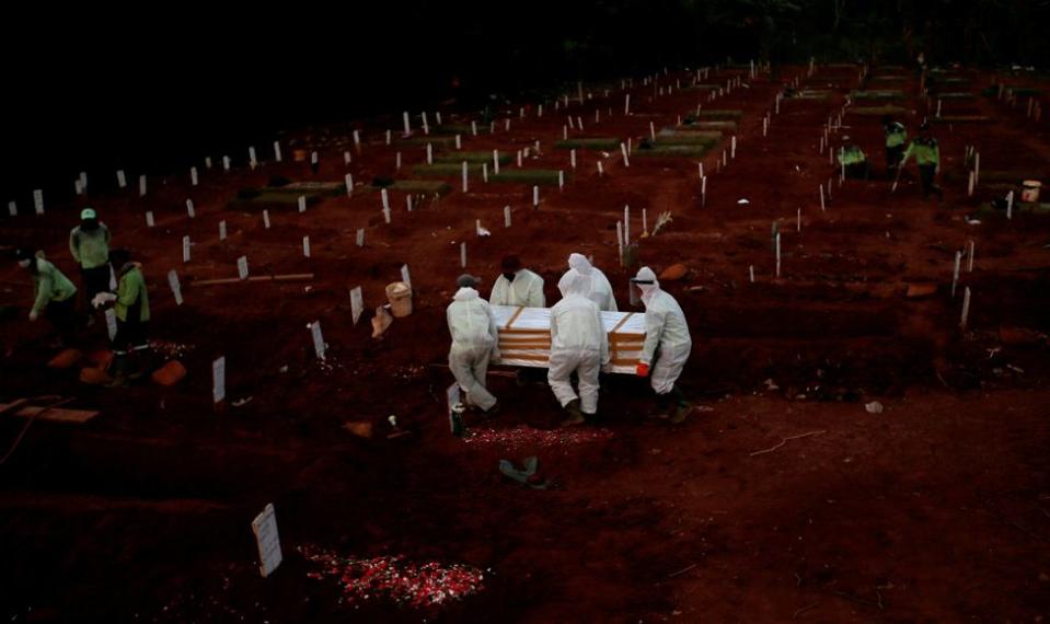 Cargan un ataúd en un cementerio para víctimas del coronavirus en Yakarta, Indonesia. A finales de abril, la Universidad Johns Hopkins informó que la cifra mundial de muertos había superado las 200.000 personas.