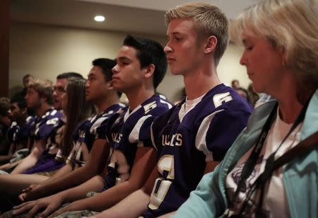 Members of the Oak Harbor High School football team, who were scheduled to play Marysville-Pilchuck High School on Friday, attend a vigil at the Grove Church following a shooting at Marysville-Pilchuck High in Marysville, Washington October 24, 2014. REUTERS/Jason Redmond