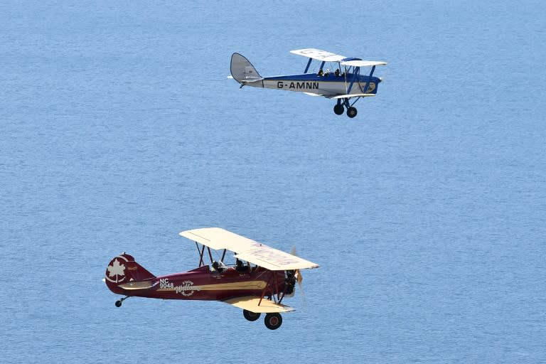 A Tiger Moth (R) and Travel Air 4000 biplane fly during a photocall for the launch of the Vintage Air Rally -- from Crete to Cape Town -- off the coast of Shoreham-by-Sea, southern England on October 10, 2016