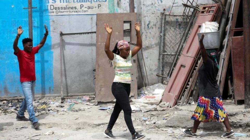 Residentes levantan los brazos mientras huyen de sus hogares debido a las continuas batallas entre bandas rivales. Puerto Pr&#xed;ncipe, Hait&#xed;, 2 de mayo de 2022.