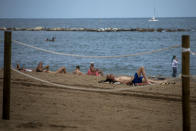 Tourists sunbathe in a beach in Barcelona, Spain, Thursday, July 16, 2020. With Europe's summer vacation season kicking into high gear for millions weary of months of lockdown, scenes of drunken British and German tourists on Spain's Mallorca island ignoring social distancing rules and reports of American visitors flouting quarantine measures in Ireland are raising fears of a resurgence of infections in countries that have battled for months to flatten the COVID-19 curve. (AP Photo/Emilio Morenatti)