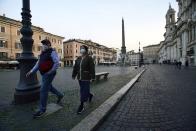 Two people walk in Rome's Piazza Navona, deserted, Tuesday evening, March 10, 2020. For most people, the new coronavirus causes only mild or moderate symptoms, such as fever and cough. For some, especially older adults and people with existing health problems, it can cause more severe illness, including pneumonia. (AP Photo/Andrew Medichini)