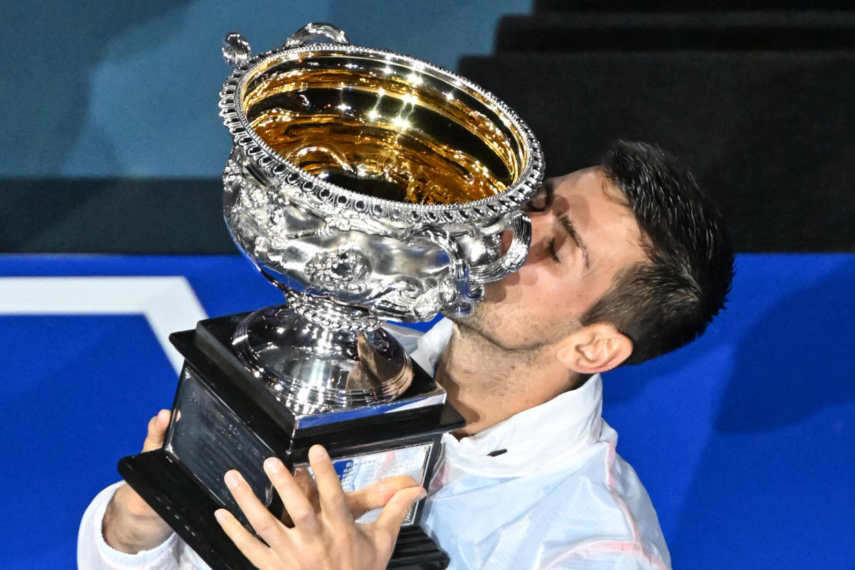 Serbia's Novak Djokovic celebrates with the Norman Brookes Challenge Cup trophy following his victory against Greece's Stefanos Tsitsipas in the men's singles final match of the Australian Open. (Photo by PAUL CROCK/AFP via Getty Images)