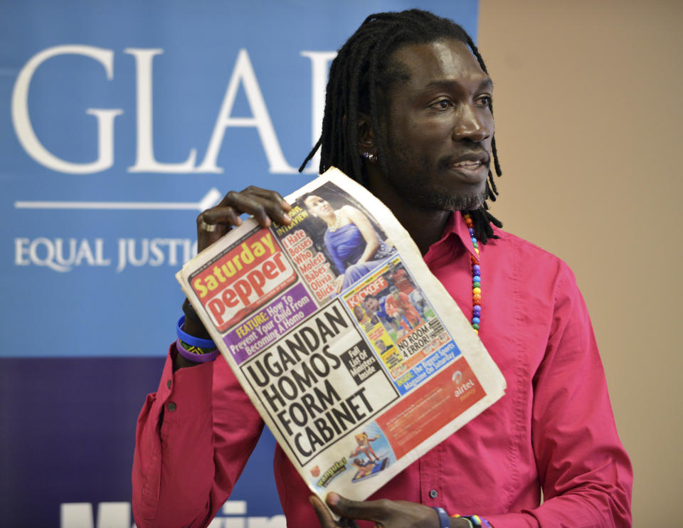 Ugandan gay-rights activist John Abdallah Wambere holds a Ugandan newspaper during a news conference Tuesday, May 6, 2014 in Boston. Wambere is seeking asylum in the U.S. to escape a harsh anti-homosexual law in his home country. The 41-year-old, who now lives in Cambridge, Mass., said Tuesday it is heartbreaking he will have to leave his community at home as well as his 16-year-old daughter, but it is too dangerous to return. (AP Photo/Josh Reynolds)
