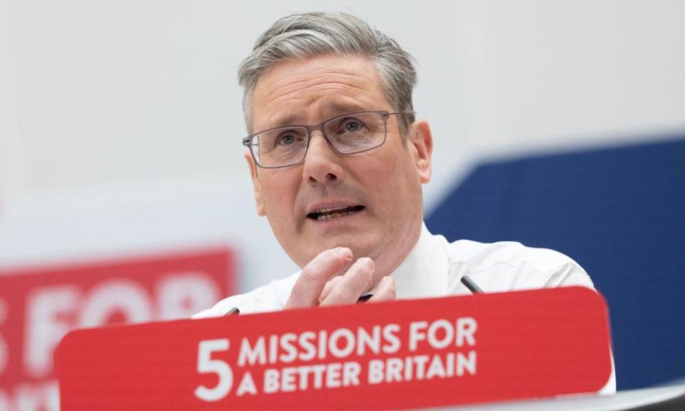 Close up of Keir Starmer gesturing as he speaks at a podium with a placard attached to it saying '5 Missions for a better Britain'