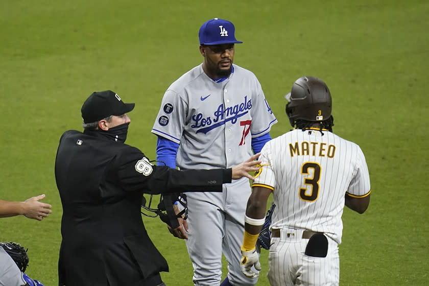 Dodgers pitcher Dennis Santana has words with the Padres' Jorge Mateo while an umpire has a hand on Mateo's arm.