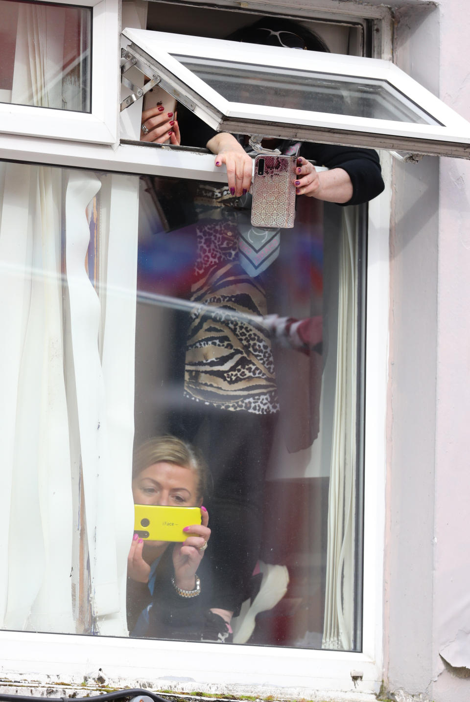 People look out of a window as the Duchess of Cambridge meets local Galwegians after a visit to a traditional Irish pub in Galway city centre on the third day of her visit to the Republic of Ireland.