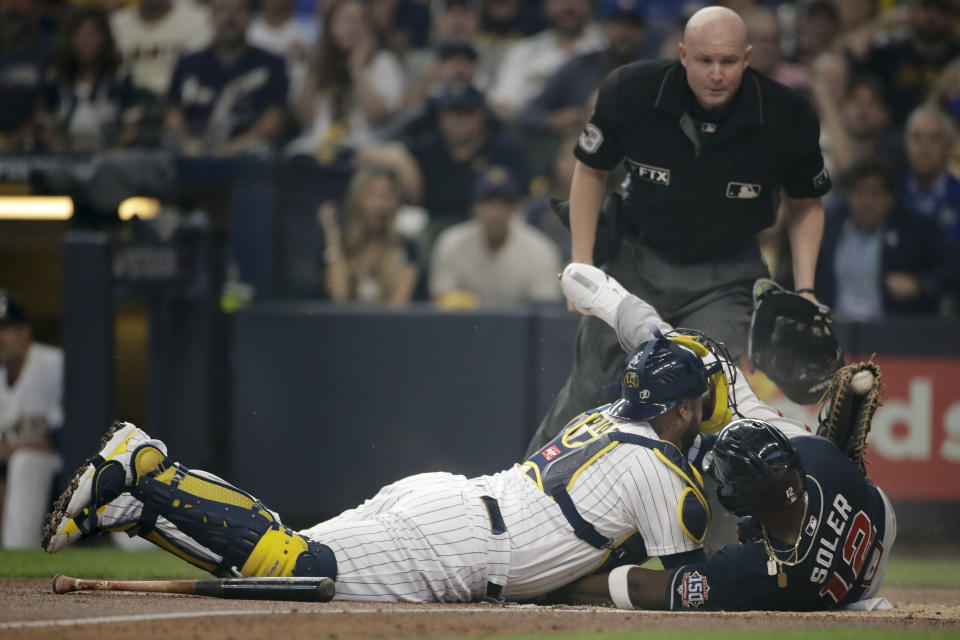 Atlanta Braves' Jorge Soler is tagged out at home by Milwaukee Brewers catcher Omar Narvaez during the first inning in Game 1 of baseball's National League Divisional Series Friday, Oct. 8, 2021, in Milwaukee. (AP Photo/Aaron Gash)