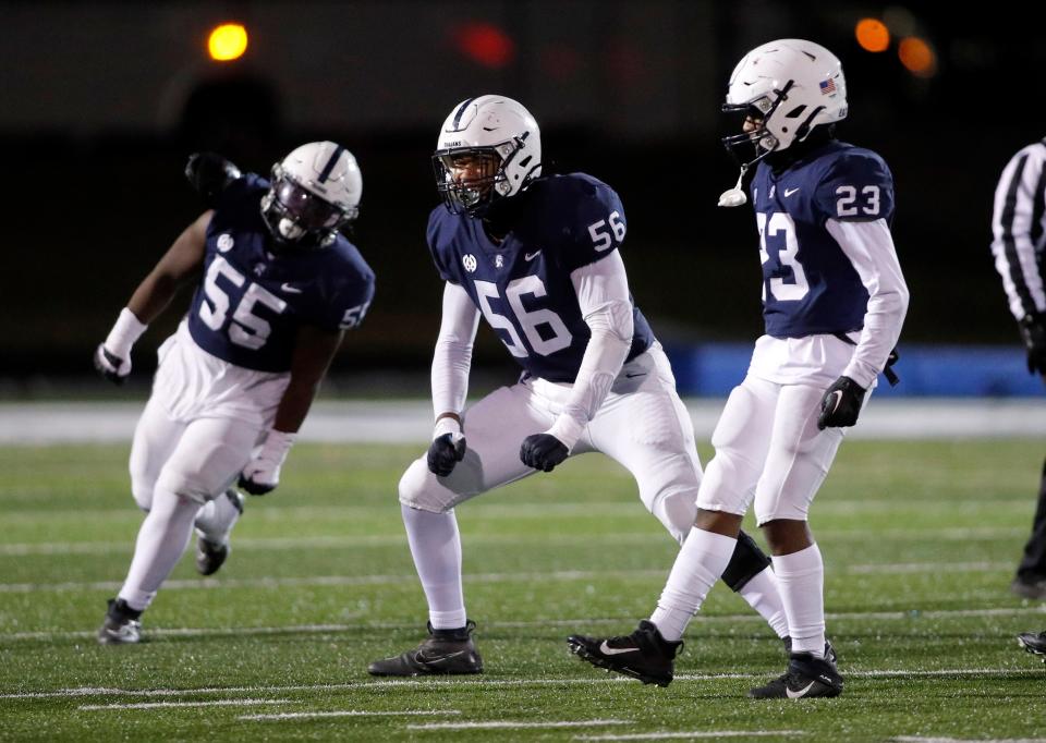 East Lansing's Javon Thomas, center, Isaiah McCrary-Sams, right, and Jay Carnegie, left, celebrate against Byron Center, Friday, Nov. 10, 2023, in East Lansing, Mich. East Lansing won 42-20.